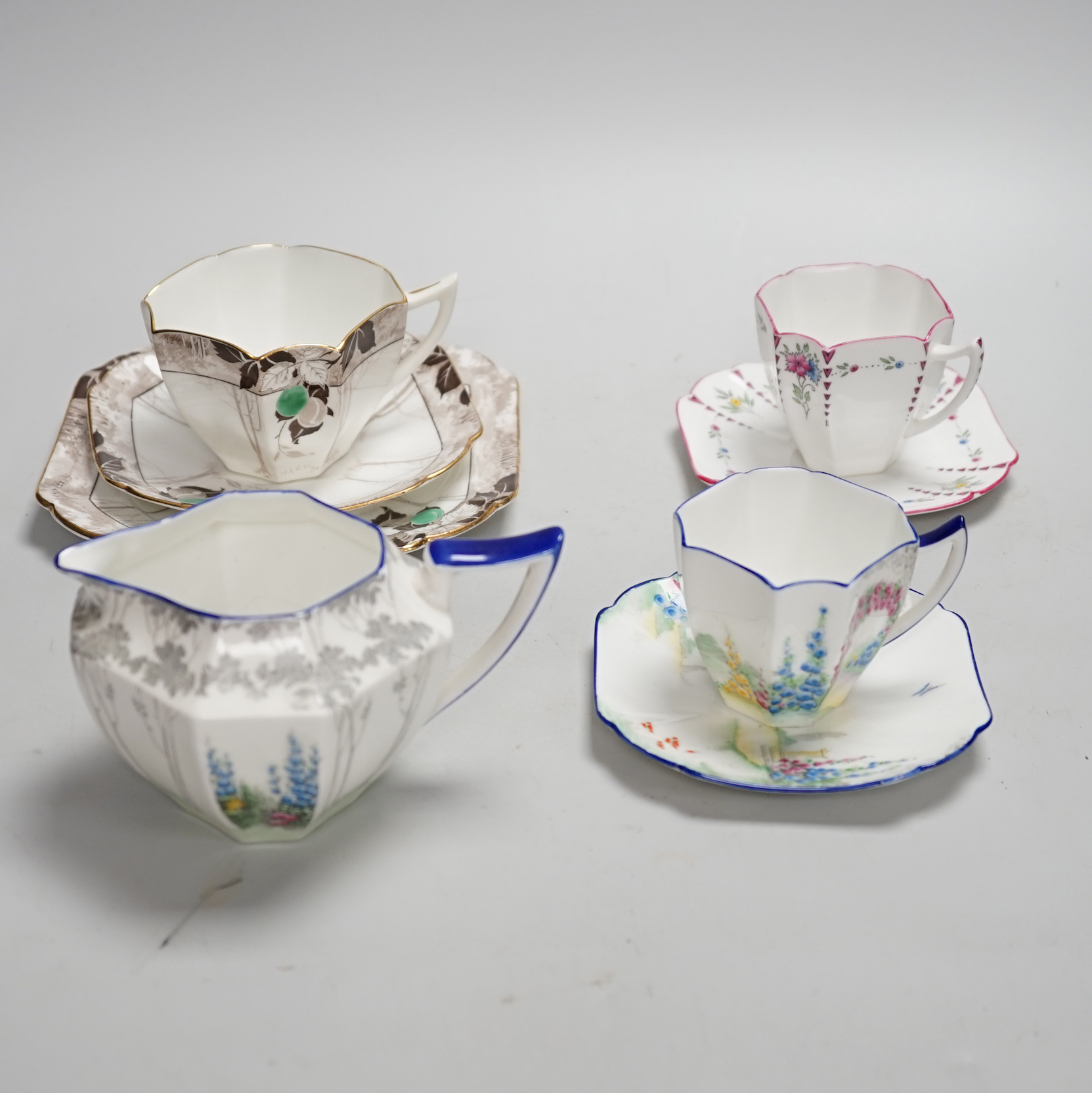 Seven Shelley Art Deco cups and saucers, three trios and a milk jug, some with Art Deco designs, largest 13cm wide